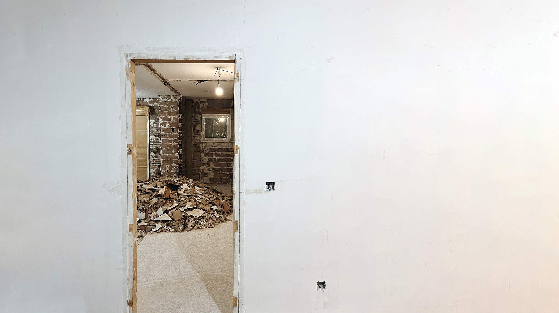 Reforma integral en una vivienda en Zaragoza. Marco de puerta y pared con un fondo en blanco.