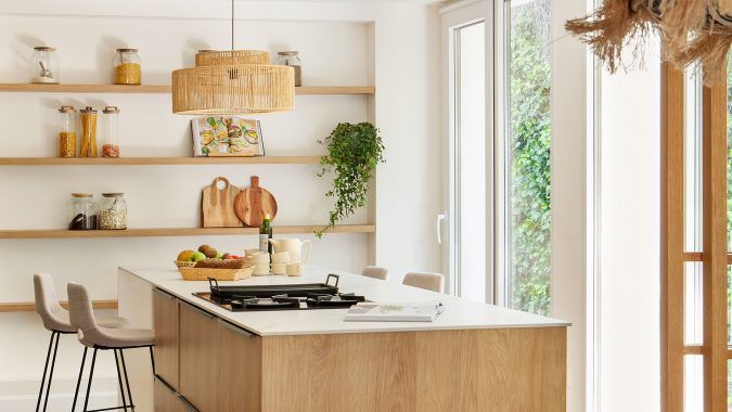 Cocina con isla en tonos crema y blancos, en una composición.