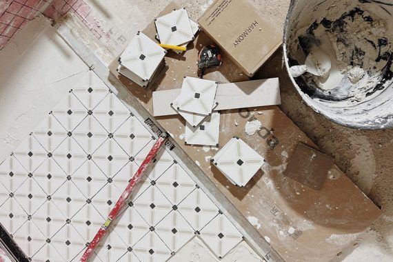 Alicatado de azulejos con patrón de diamante blancos y negros.
