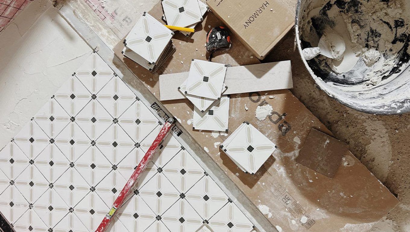 Alicatado de azulejos con patrón de diamante blancos y negros.