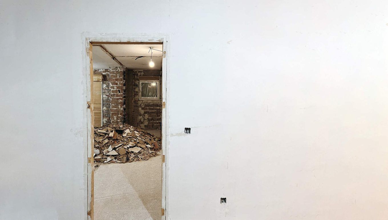 Reforma integral en una vivienda en Zaragoza. Marco de puerta y pared con un fondo en blanco.